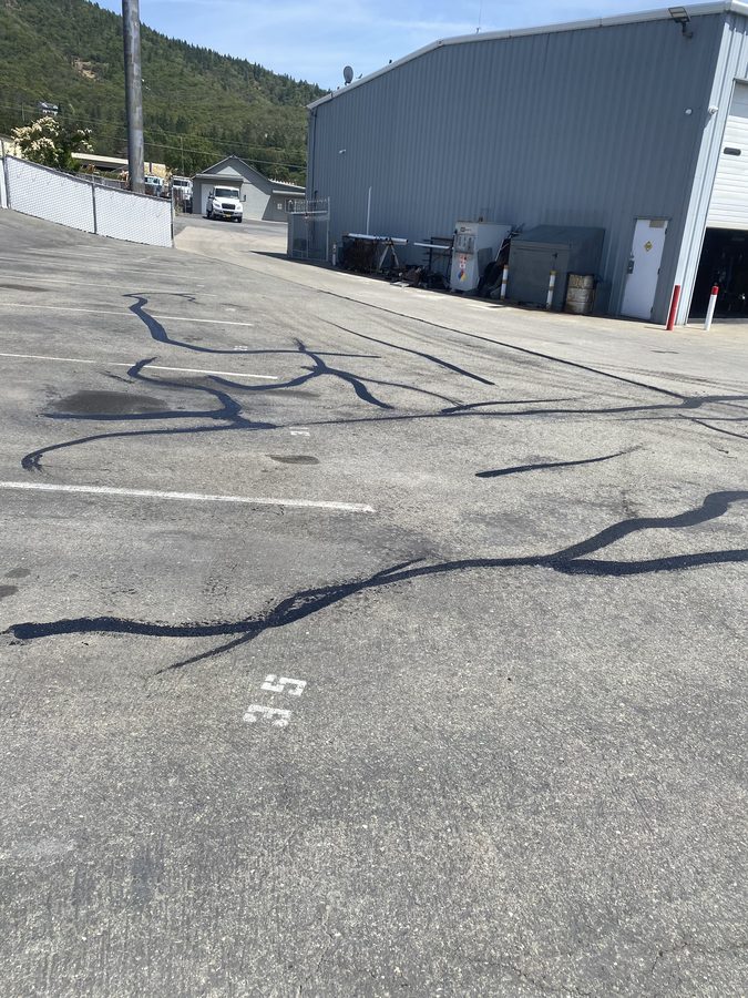 Hot-pour crack filling sealing cracks on the Caveman Towing parking lot in Grants Pass, Oregon