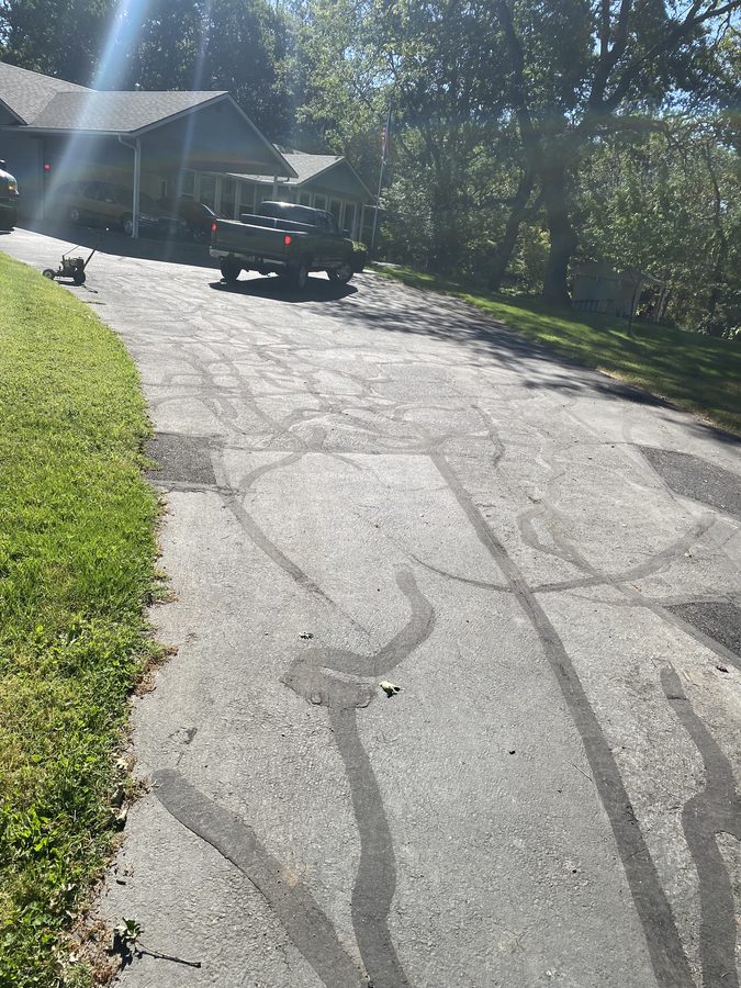 Aging asphalt driveway with heavy alligator cracking before repair on Soldier Creek Road in Grants Pass, Oregon