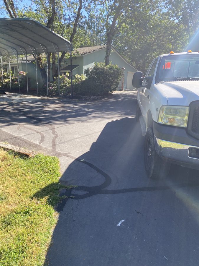 Driveway with hot rubberized crack filler applied over cracks before sealcoating on Soldier Creek Road in Grants Pass, Oregon