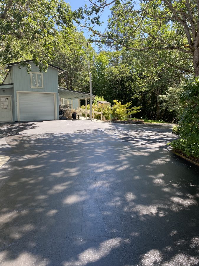 Freshly sealcoated asphalt driveway with a deep-black finish after crack filling on Soldier Creek Road in Grants Pass, Oregon