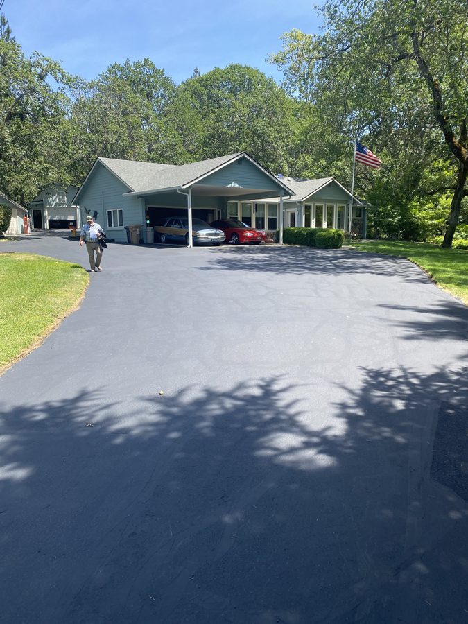 Driveway with a smooth, uniform black finish after crack filling and sealcoating on Soldier Creek Road in Grants Pass, Oregon