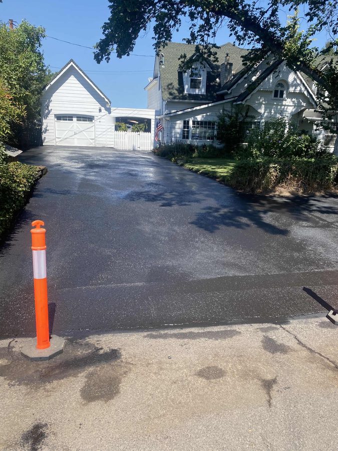 Long residential driveway sealcoated end to end and blocked off with a traffic cone to cure on Hazel Street in Central Point, Oregon